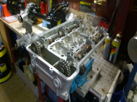 Een cilinderkop met nokkenassen op de werkbank.