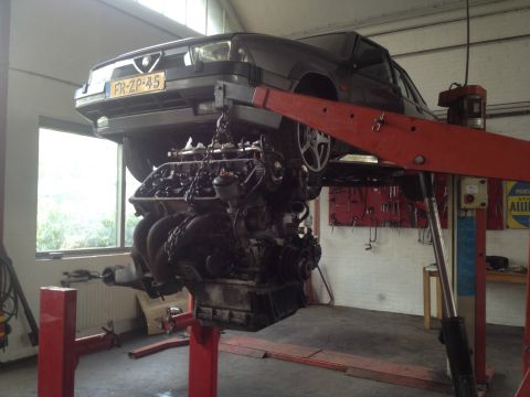 Een Alfa Romeo aan de hijskraan, met de motor eronder.