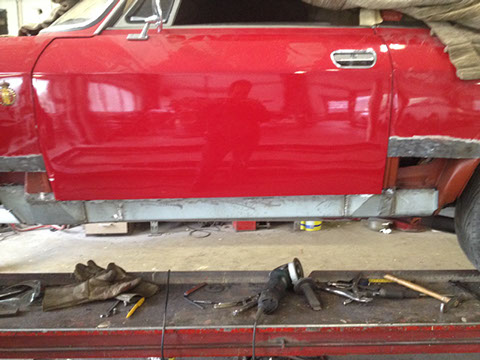 De zijkant van de Giulia Sprint GT in de rode lak, de dorpel in een lichte kleur.